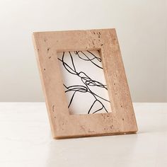 a wooden frame with a black and white drawing on the inside is sitting on a table