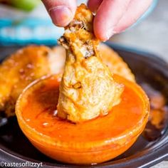 a person dipping something into an orange dish