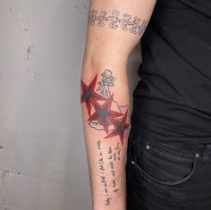 a man's arm with red stars on it and writing underneath the star is written in black ink