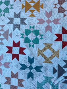 a close up of a quilt with many different colored stars on the front and back