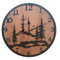 a wooden clock with trees and mountains on it