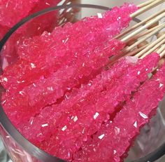 some pink rocks and wooden sticks in a bowl