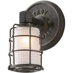 a light that is on the side of a metal wall mounted fixture with a white glass shade