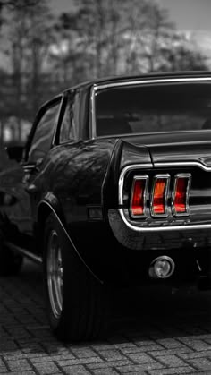 the rear end of an old black mustang