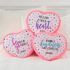 three heart shaped pillows that say follow your heart and sparkle like confetti on them