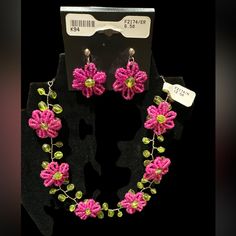 a necklace and earring set with pink flowers