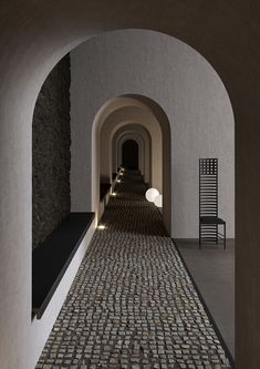 an archway leading to a long hallway with stone flooring and brickwork on the walls