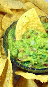 a bowl filled with guacamole surrounded by tortilla chips