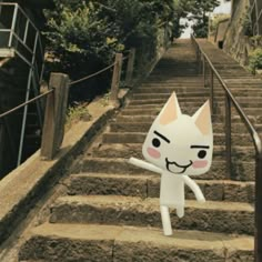 a white cat is standing on some steps and pointing at the camera with his hand