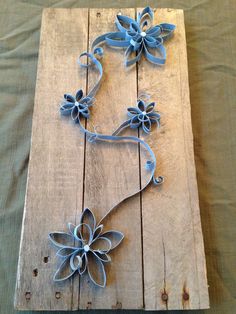 a piece of art made out of wood with metal flowers on the top and bottom