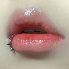 a woman's tongue with spikes sticking out of the middle of her lip and on top of it