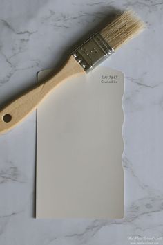 a paint brush sitting on top of a white piece of paper