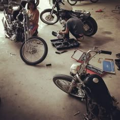 several people working on motorcycles in a garage