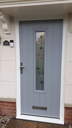 a blue front door with glass on the side and brick wall in the back ground