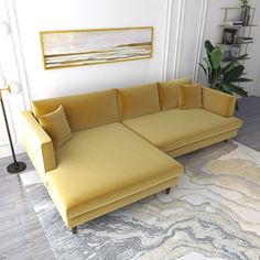 a yellow couch sitting on top of a rug in a living room