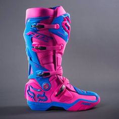 a pair of pink and blue motorcycle boots on a gray background with space for text