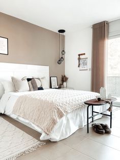 a bedroom with a bed, rugs and pictures on the wall