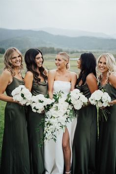 a group of women standing next to each other holding bouquets