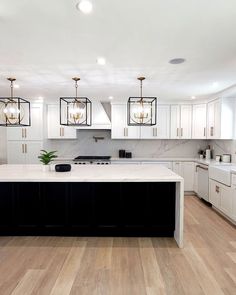 a large kitchen with white cabinets and black island