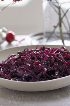 a white bowl filled with red cabbage on top of a table