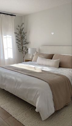 a bedroom with a large bed and white curtains