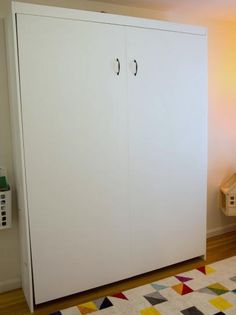 a white cabinet sitting on top of a wooden floor