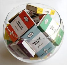 a glass bowl filled with different types of candy bars on top of a white table