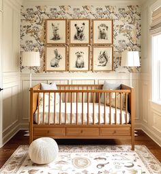 a baby's room with pictures on the wall and a crib in front of it