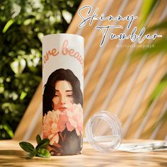 there is a cup with an image of a woman on it next to some flowers