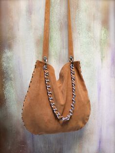 "Suede leather hobo bag hand made with italian genuine leather \" COGNAC COLOR \" Original design new limited edition collection \" boho chic bags agnès de juliis - one of a kind bags The Melanie bag is completely handmade, no seams, but it is assembled by carefully work with metal studs. They are made one at a time, each piece is unique. Has two handles, to be worn as a shoulder bag or even as crossbody ! OPTION : - SILVER OR BRASS HARDWARE - TASSEL CHARMS if you want add it, you can select \" Leather Hobo Bag With Chain Strap For Daily Use, Leather Hobo Bag With Chain Strap For Everyday, Leather Hobo Bag With Chain Strap, Boho Chic Bags, Hobo Crossbody Bag, Cognac Color, Hobo Bags, Chic Bags, Leather Hobo Bag