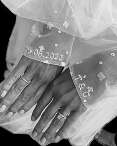 the bride and groom are holding hands with wedding rings on their fingers, while they both wear diamond - encrusted bands