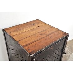 an old metal and wood side table with holes