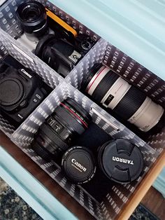 four cameras sitting in a box on top of a table