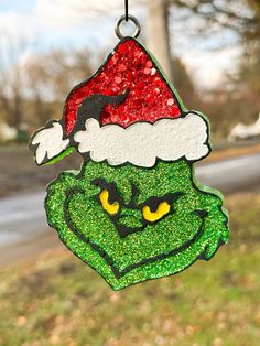 an ornament hanging from the side of a tree with a grin face on it