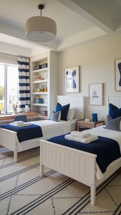 two beds in a bedroom with blue and white decor