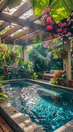 an outdoor swimming pool surrounded by greenery and flowers in the middle of a garden