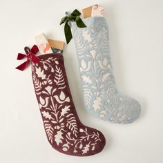 two christmas stockings with bows and tags on them