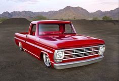 an old red truck is parked in the desert