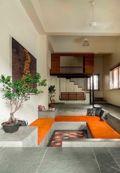 a living room filled with furniture and a tree in the middle of it's center