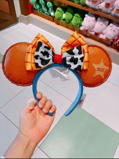 a person holding up a mickey mouse ears headband