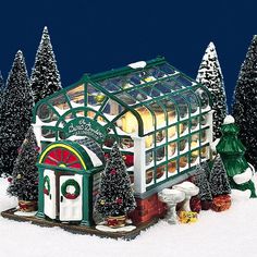 a christmas scene with a lit up store in the middle of trees and snow on the ground