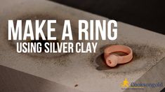 a ring sitting on top of a cement block with the words make a ring using silver clay