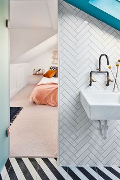 a bathroom with a sink, mirror and bed in the corner next to each other