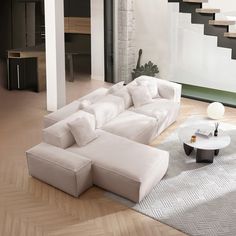 a large white couch sitting on top of a wooden floor next to a coffee table