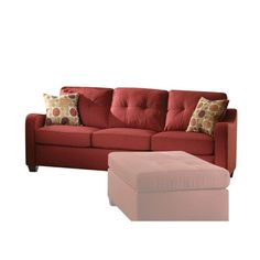 a red couch with pillows and a footstool