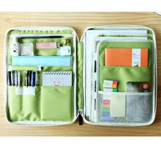 an open green and white case with various items in it on top of a wooden table