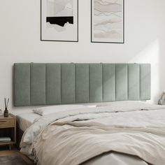 a bed with two pictures hanging on the wall above it