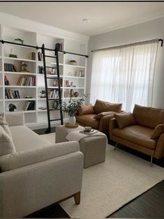 a living room with two couches and a ladder in the middle of it,