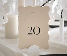 there is a sign with the number 20 on it next to candles and vases