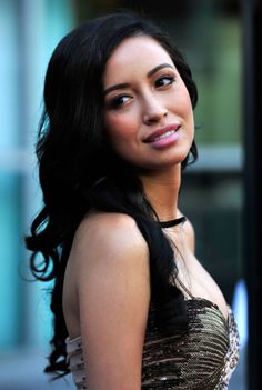 a close up of a person wearing a dress and posing for the camera with her hand on her hip